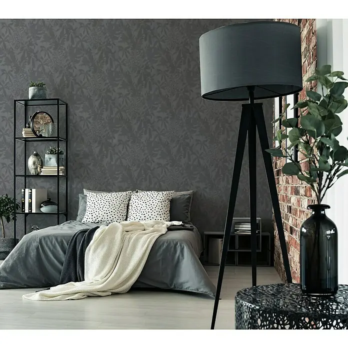 A.S. Création Daniel Hechter 7 Vliestapete Florale Schatten - Grau-Schwarz, Floral, 10,05 x 0,53 m - Ein Schlafzimmer mit einem grauen Bett, einem schwarzen Regal und einer großen Stehlampe für eine gemütliche Atmosphäre.