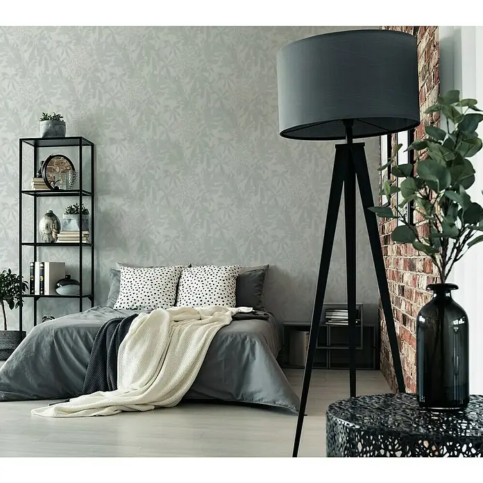 A.S. Création Daniel Hechter 7 Vliestapete Florale Schatten - Grün-Grau-Weiß, Floral, 10,05 x 0,53 m - Schlafzimmer mit einem modernen Tripod Stehleuchte mit grauem Lampenschirm, das Zimmer beleuchtet und eine gemütliche Atmosphäre schafft.