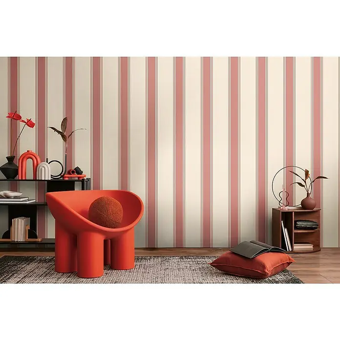A.S. Création Michalsky Metropolis Vliestapete - Creme-Rot, Streifen, 10,05 x 0,53 m - Wohnzimmer mit einem markanten roten Sessel, ergänzt durch eine stilvolle Tapete mit Streifenmuster. Elegante Details vervollständigen das moderne Interieur.