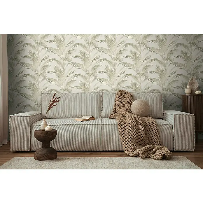 A.S. Création Michalsky Metropolis Vliestapete Palmwedel - Creme-Grün, Floral, 10,05 x 0,53 m - Gemütliches Wohnzimmer mit einem stilvollen, beigen Cordsofa, einer Strickdecke und einem dekorativen Beistelltisch.