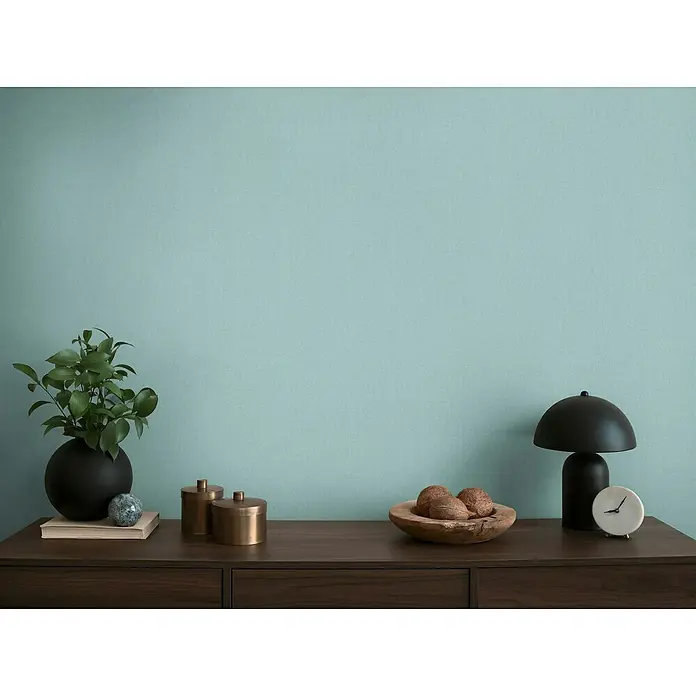 A.S. Création Michalsky Metropolis Vliestapete - Blau, Uni, 10,05 x 0,53 m - Dekorative Kommode mit eleganten Accessoires wie einer Lampe, Pflanze und Schalen, die eine stilvolle Raumatmosphäre schafft.