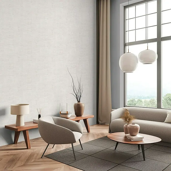A.S. Création Daniel Hechter 7 Vliestapete - Creme-Weiß, Streifen, 10,05 x 0,53 m - Wohnzimmer mit beigem Sessel, Couchtisch und Sofa, akzentuiert durch die Textur der Wand. Das natürliche Licht betont die Einrichtung des Raumes.
