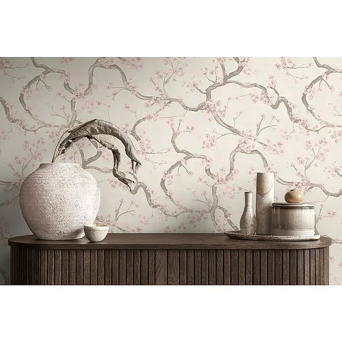 A.S. Création Metropolitan Stories Hot Spots Vliestapete Kirschblüte - Creme-Rosa-Beige, Floral, 10,05 x 0,53 m - Eine Nahaufnahme eines dekorierten Tisches mit diversen Vasen und Keramikgefäßen vor einer Wand mit Kirschblütenmuster.