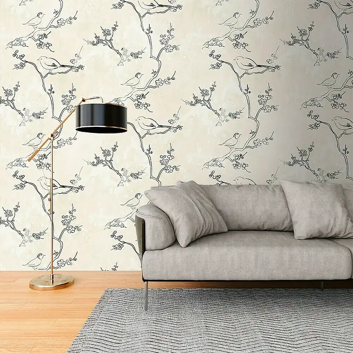 A.S. Création The Wall 3 Fototapete Vögel - B x H: 159 x 280 cm, Vlies - Nahaufnahme eines Zimmers mit einem bequemen Sofa, einer Stehlampe und einer Wand mit einem zarten Vogel- und Blumenmuster.