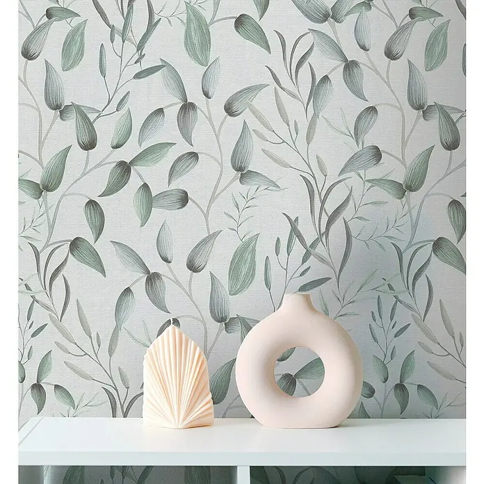 A.S. Création Pintwalls 2 Vliestapete Blätterranke - Grün-Weiß-Grau, Floral, 10,05 x 0,53 m - Helle Studioaufnahme einer Kerze und einer rosafarbenen Donut-Vase auf einem weißen Regal vor einem grünen Blätterhintergrund.