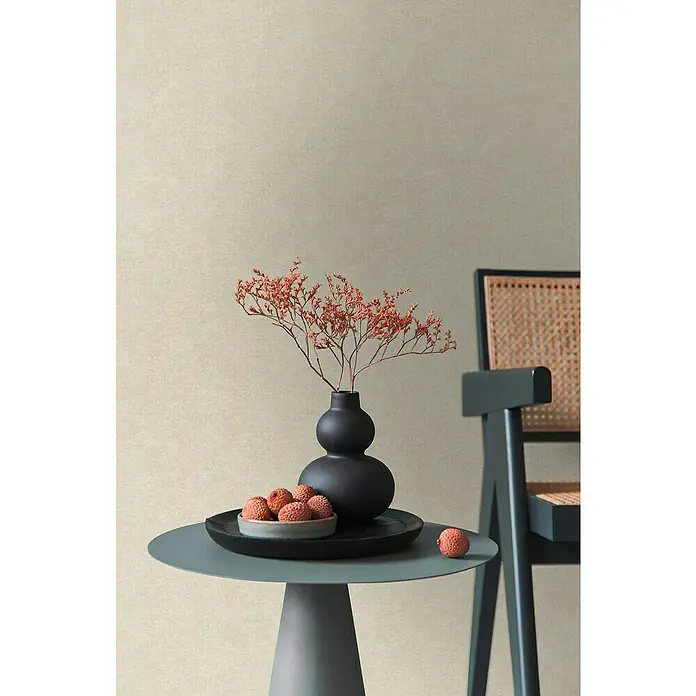 A.S. Création Metropolitan Stories Hot Spots Vliestapete - Hellbeige, Uni, 10,05 x 0,53 m - Elegantes Stillleben mit einer modernen grauen Beistelltisch-Szene, einer dekorativen Vase und einem stilvollen Holzstuhl mit Rohrgeflecht.