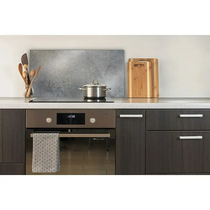 CUCINE Küchenrückwand - Dark Concrete, 80 x 40 cm, Stärke: 6 mm, Einscheibensicherheitsglas (ESG) - Küchenstillleben mit einem modernen Herd, Kochutensilien und Schneidebrettern auf einer stilvollen Arbeitsfläche.