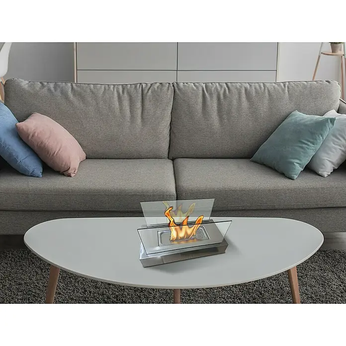 Purline Chimenea de bioetanol Algeiros - Acero inoxidable, Plateado - Una moderna chimenea de etanol sobre una mesa, creando un ambiente cálido y acogedor en una sala de estar elegante.