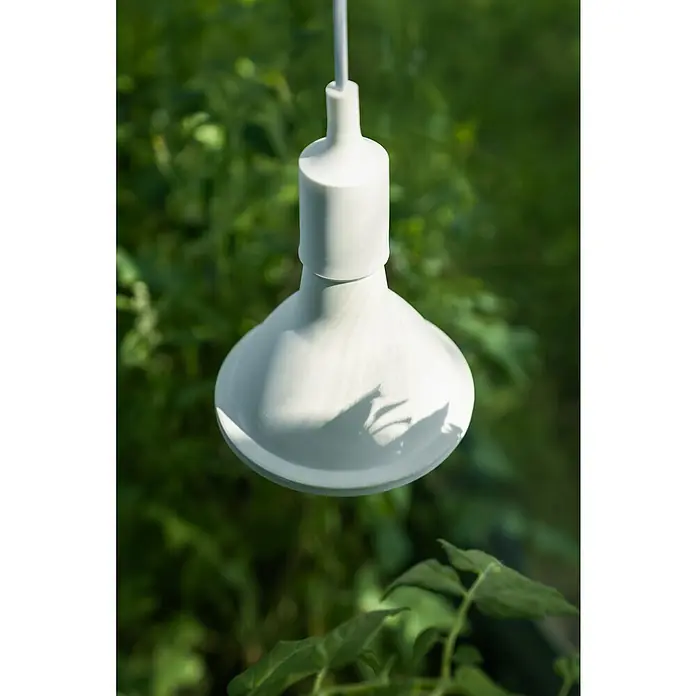 Vitavia Pflanzenlampe Grow 95 - E27, PAR38 - Hängende, glockenförmige, matte, weiße Lampe mit Kabel vor einem unscharfen, grünen Hintergrund.