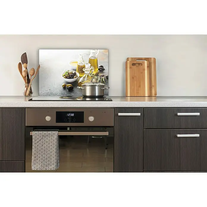 CUCINE Küchenrückwand - Fine Olive, 60 x 40 cm, Stärke: 6 mm, Einscheibensicherheitsglas (ESG) - Einbauküche mit Herd und Deko: Oliven-Wandbild, Kochutensilien und Schneidebretter schmücken die moderne Küche.