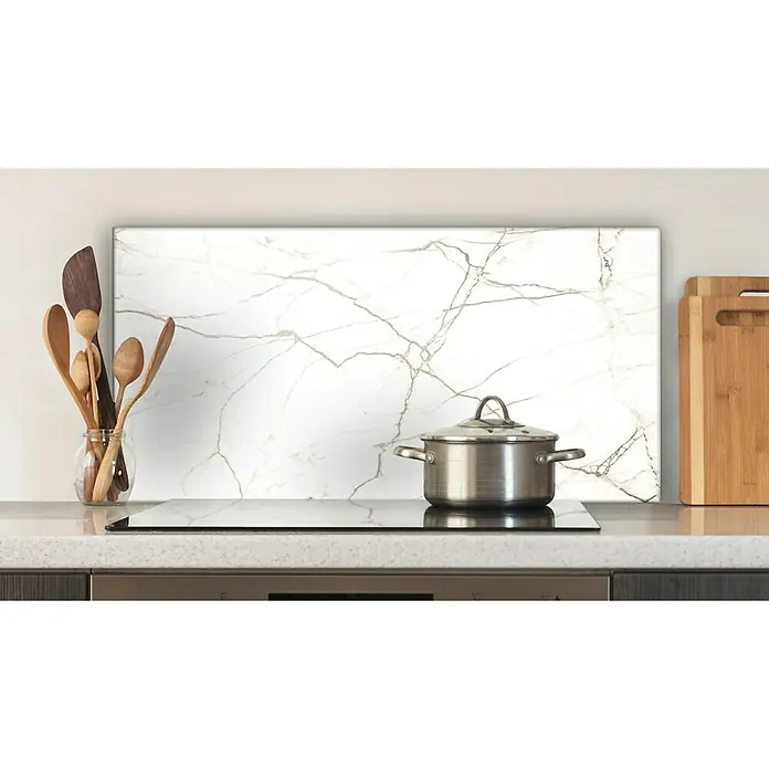 CUCINE Küchenrückwand - White Marble, 80 x 40 cm, Stärke: 6 mm, Einscheibensicherheitsglas (ESG) - Ein Edelstahlkochtopf mit Deckel steht auf einem schwarzen Kochfeld in einer modernen Küche mit Marmor-Akzentwand.