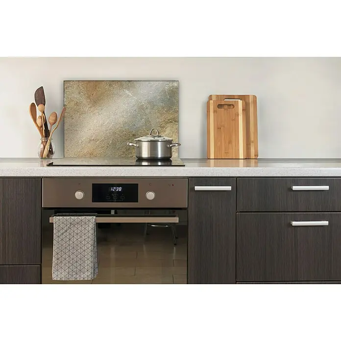 CUCINE Küchenrückwand - Golden Marble, 60 x 40 cm, Stärke: 6 mm, Einscheibensicherheitsglas (ESG) - Nahaufnahme einer modernen Küche mit Backofen, Kochfeld, Kochtopf, Schneidebrettern und Utensilien. Der Fokus liegt auf dem stilvollen Küchendesign.