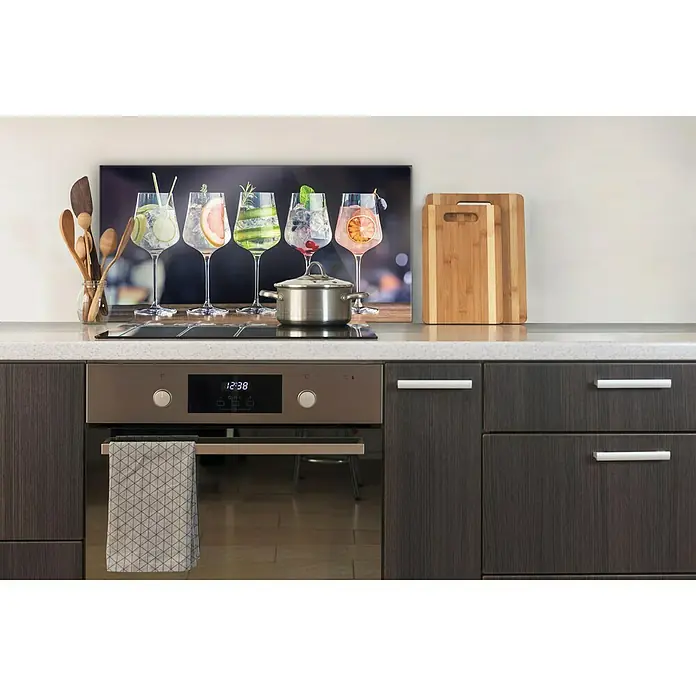 CUCINE Küchenrückwand - Fruity Gin, 80 x 40 cm, Stärke: 6 mm, Einscheibensicherheitsglas (ESG) - Küchenrückwand mit Cocktail-Motiv über dem Herd. Küchenutensilien, Schneidebretter und ein Topf ergänzen das Bild.
