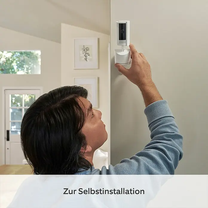 Ring Innenkamera beweglich Pan-Tilt Indoor Camera - 1.080 Pixel (Full HD), Weiß - Ein Mann installiert eine Ring Sicherheitskamera an einer Wand, mit dem Fokus auf die einfache Selbstinstallation des Geräts.