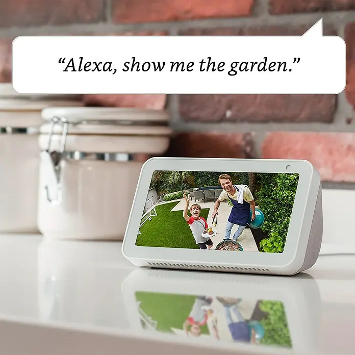 Ring Außenkamera Akku Plus - 2.048 x 1.536 Pixel (2K-HD), Schwarz - Das Amazon Echo Show-Gerät zeigt eine Live-Aufnahme aus dem Garten, während es auf den Sprachbefehl „Alexa, zeig mir den Garten“ reagiert.