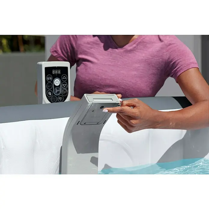 Bestway Lay-Z-Spa Schwalldusche Xtras LED - Passend für: Bestway® AirJet™, AirJet Plus™ & UltraFit™ - Whirlpools - Nahaufnahme einer Person, die ein aufblasbares Spa mit digitaler Steuerung bedient, um Entspannung und Komfort zu Hause zu genießen.