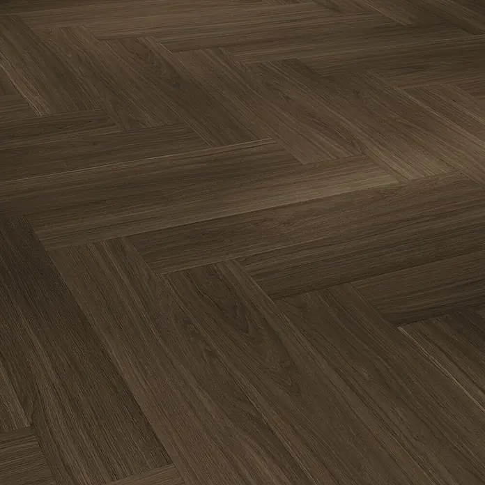 Parador Vinylboden Trendtime 3 - Eiche Oxford dunkelbraun, Fischgrät, 730 x 146 x 5 mm - Ansicht von dunklem Holzparkett mit einem Fischgrätenmuster. Der Bodenbelag erzeugt eine warme und einladende Atmosphäre.