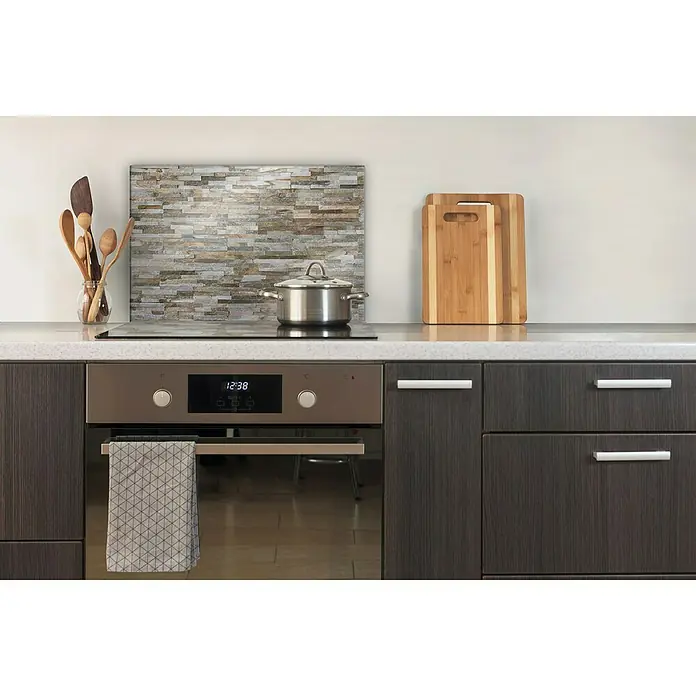 CUCINE Küchenrückwand - Rocky Wall, 60 x 40 cm, Stärke: 6 mm, Einscheibensicherheitsglas (ESG) - Moderne Küche mit Edelstahlherd und -töpfen, Holzutensilien und Schneidebrettern auf einer dunklen Arbeitsfläche.