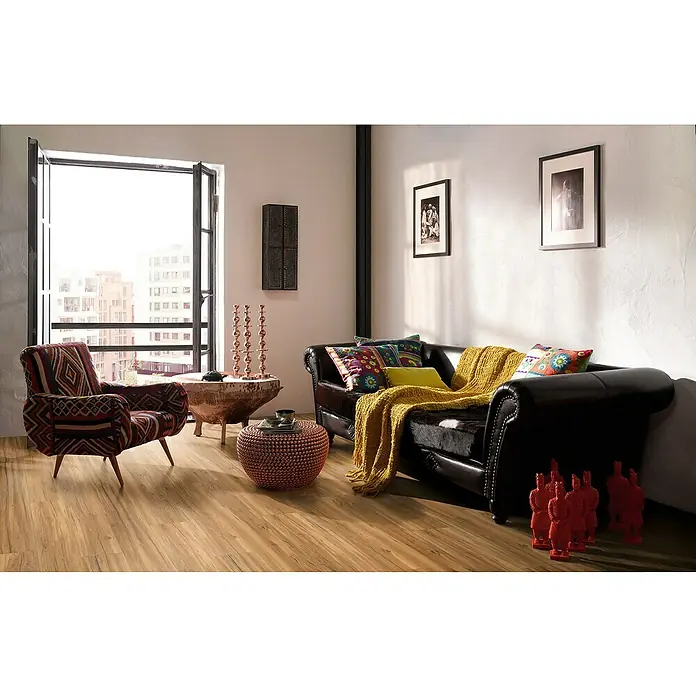 Parador Vinylboden Classic 2030 - Eiche Memory natur Gebürstete Struktur, Landhausdiele, 1.207 x 216 x 9,6 mm - Wohnzimmer mit dunklem Ledersofa, gemustertem Sessel und Holzboden. Dekorative Elemente wie Kissen und Statuen ergänzen das Ambiente.