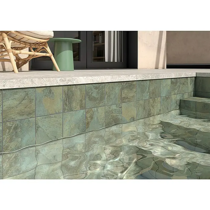 Decocer by Cinca Feinsteinzeugfliese Splash Green - 15 x 15 cm, Grün, Matt - Nahaufnahme eines Pools mit Fliesen in Naturtönen und klarem, wellenförmigem Wasser. Einladend und entspannend.