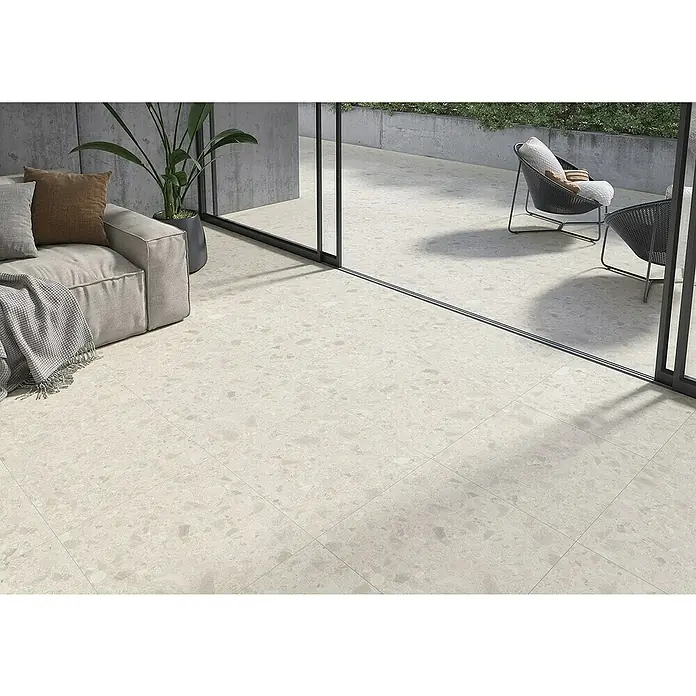 Feinsteinzeugfliese Ceppo Gres 8997 - 60 x 60 cm, Beige, Matt - Innenaufnahme eines Raumes mit hellbeige Bodenfliesen im Terrazzo-Stil, ergänzt durch moderne Möbel und Tageslicht.