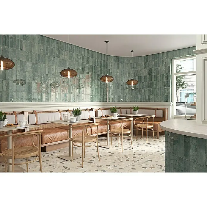 Wandfliese Infinity 9185 - 7,5 x 25 cm, Grün, Glänzend - Elegantes Restaurant mit aquamarinblauen Wandfliesen, die eine ruhige Atmosphäre schaffen, ergänzt durch stilvolle Pendelleuchten und gemütliche Sitzbereiche.