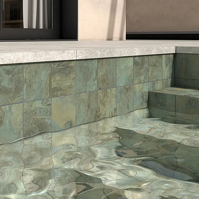 Decocer by Cinca Feinsteinzeugfliese Splash Green - 15 x 15 cm, Grün, Matt - Nahaufnahme von Steinzeugfliesen am Rand eines Pools, die einen natürlichen und robusten Look mit Wassereffekten kombinieren.