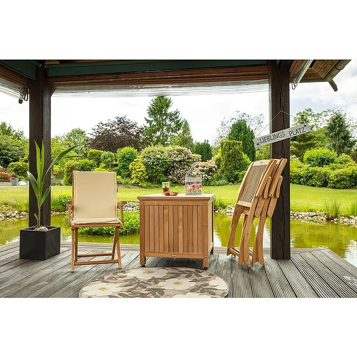 Kai Wiechmann Gartenstuhl - Teakholz, Klappbar, Naturbelassen, B x T x H: 58 x 60 x 94 cm - Gartenmöbel-Set auf einer Terrasse mit Blick auf einen Teich. Das Set beinhaltet einen Tisch, einen Stuhl und einen Blumenständer.