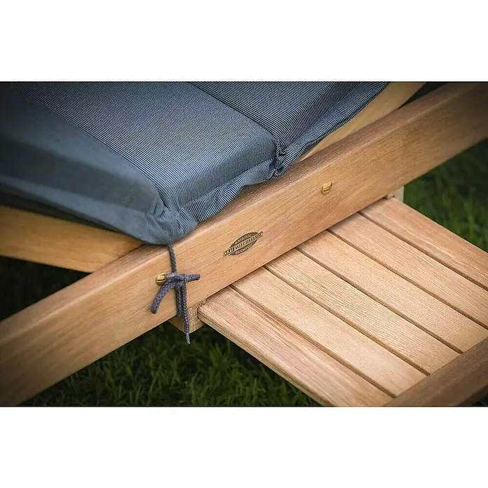 Kai Wiechmann Gartenliege - Naturbelassen, Holz, Rollbar - Detailaufnahme einer luxuriösen Gartenliege mit Auflage und Fußstütze aus hellem Holz.