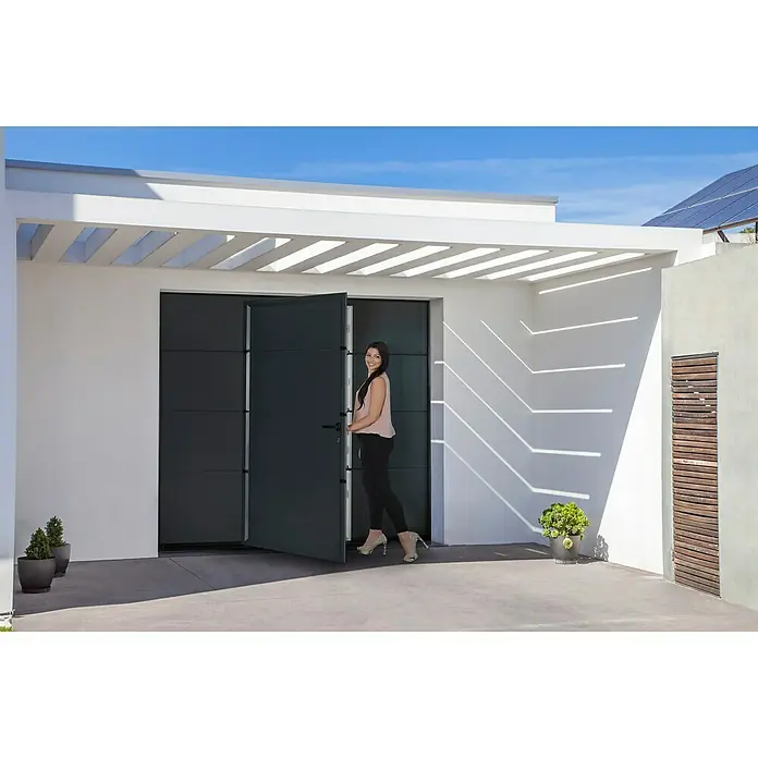 Garagentor mit Schlupftür - B x H: 2.500 x 2.125 mm, Anthrazitgrau/Weiß, Glatt - Frau betritt ein modernes Haus mit einer markanten, zweiflügeligen Garagentür. Die Tür ist ein echter Hingucker.