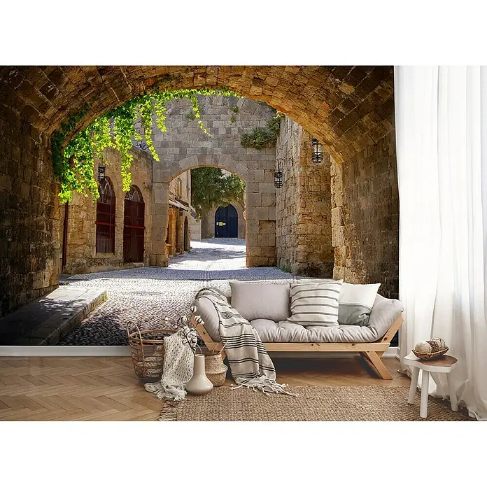 Fototapete Tunnel IIB x H: 312 x 219 cm, Vlies - Ein Wandbild, das eine Steingasse mit einem Torbogen und einem angedeuteten Wohnbereich zeigt, schafft eine einladende Atmosphäre.