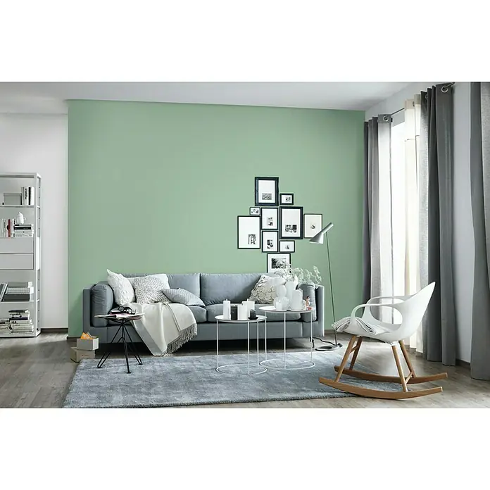 SCHÖNER WOHNEN-Farbe Wandfarbe Trendfarbe Limited Collection - Spa, Matt, 1 l, Konservierungsmittelfrei - Wohnzimmer mit einem grauen Sofa, einem hellgrünen Hintergrund und einem weißen Schaukelstuhl, der dem Raum eine elegante und moderne Note verleiht.