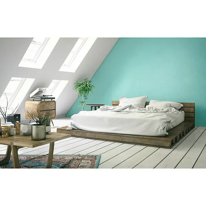 SCHÖNER WOHNEN-Farbe Wandfarbe TrendfarbeFrozen, Matt, 1 l, Konservierungsmittelfrei - Gemütliches Schlafzimmer mit einem hellen Holzbett auf einem Podest, weißen Bettbezügen und Akzenten in Grün und Holz für eine entspannte Atmosphäre.