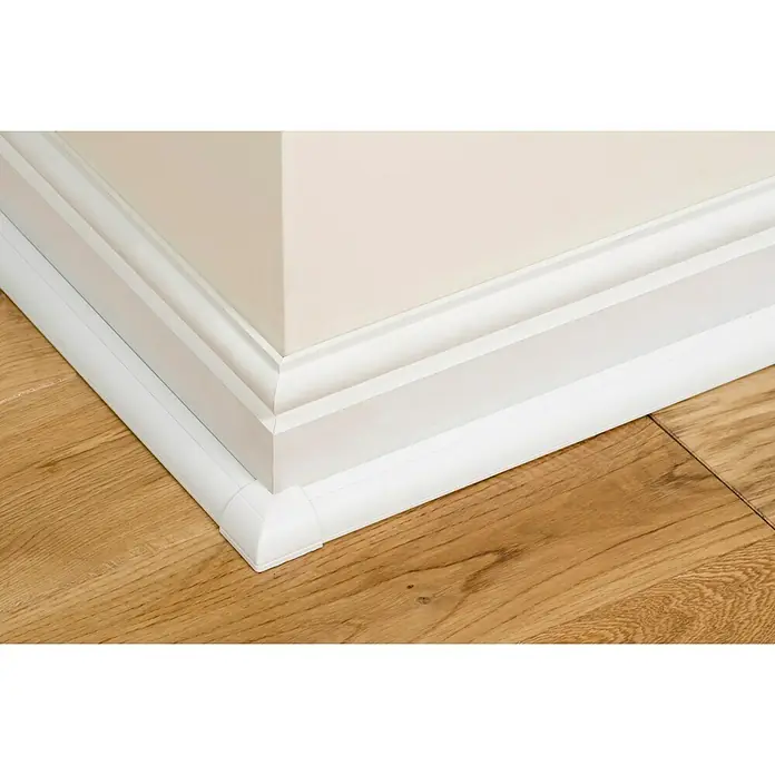 D-Line Kabelkanal Viertelrund - 1 m, 22 x 22 mm, Weiß - Nahaufnahme einer weißen Fußleiste, die einen eleganten Übergang zwischen Wand und Holzboden bildet. Schützt die Wand vor Beschädigungen.