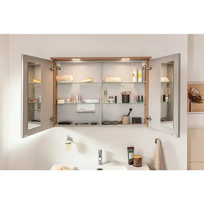 Fackelmann Vita LED-Spiegelschrank - B x H: 100,2 x 69,6 cm, Summer Oak - Ein offener Badezimmerschrank mit Glasböden und verschiedenen Badartikeln, beleuchtet von oben. Praktische Aufbewahrung im Bad.