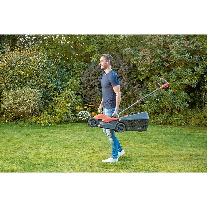 Black+Decker Cortacésped eléctrico BEMW451BH-QS - 1.200 W, Ancho de corte: 32 cm - Un hombre lleva un cortacésped ligero de color naranja con una cesta recogedora delante de un jardín verde.