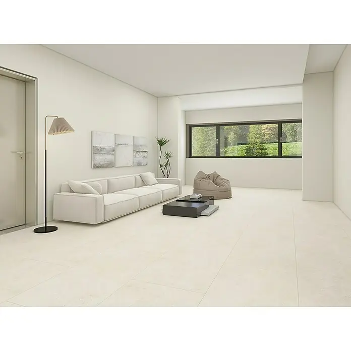 Vinylbodenmuster Rigid Fliese Palma - 297 x 180 x 5,5 mm, Steinoptik - Helle, moderne Wohnung mit beigem Sofa, Lampe, Couchtisch und Fenster mit Blick auf die Natur, die eine entspannende und einladende Atmosphäre schafft.