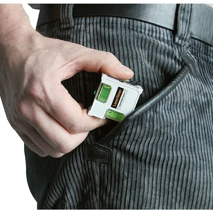 Laserliner Linienlaser Lasercube Green - Max. Arbeitsbereich: 0 m - 10 m - Nahaufnahme eines Mannes, der einen Laserliner LaserCube Green in seine Tasche steckt.