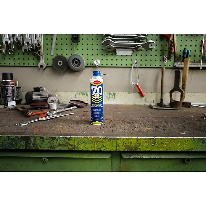 Caramba Multiöl 70 - 400 ml - Caramba 70 Multifunktionsöl-Spraydose auf Werkbank.