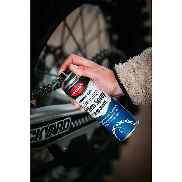 Caramba Kettenspray Performance - 300 ml - Die Kette eines Motorrads wird mit Caramba Kettenöl-Spray Transparent geschmiert, um Verschleiß zu mindern und Korrosion zu verhindern.
