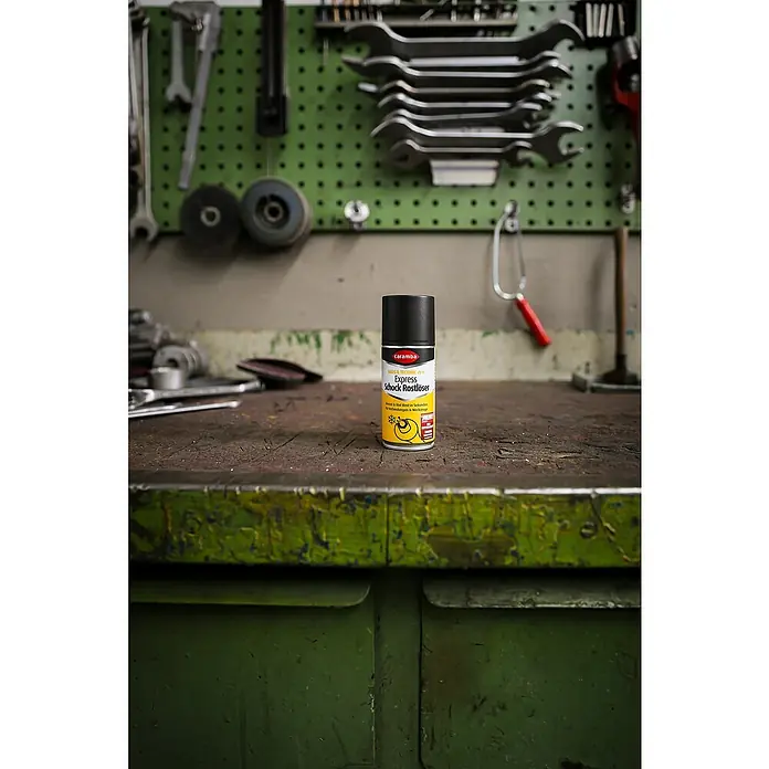 Caramba Rostlöser Express - 100 ml - Caramba Express Schock Rostlöser Dose steht auf einer Werkbank vor Werkzeugen.
