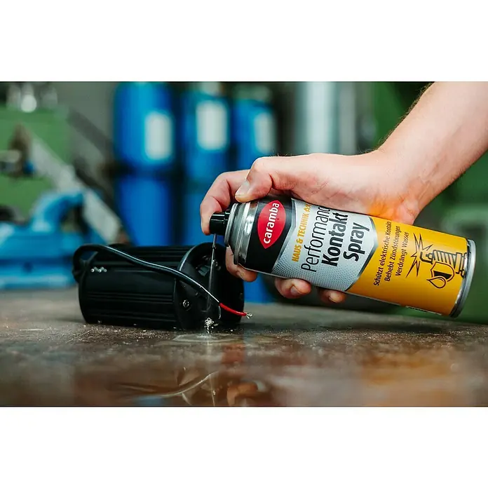 Caramba Kontaktspray Performance - 250 ml - Anwendung von Caramba Kontaktspray auf ein elektronisches Gerät, um Kontakte zu schützen und Zündstörungen zu beheben.
