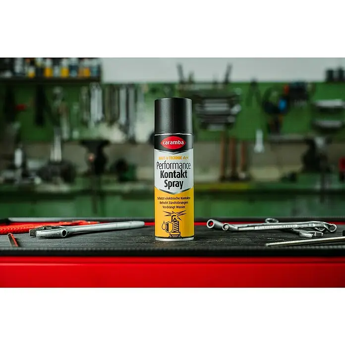 Caramba Kontaktspray Performance - 250 ml - Caramba Performance Kontaktspray auf einer Werkbank. Schützt elektrische Kontakte, behebt Zündstörungen und verdrängt Wasser.