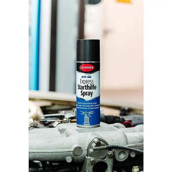 Caramba Starthilfespray Express - 300 ml - Eine Dose Caramba Express Starthilfe Spray auf einem Automotor.
