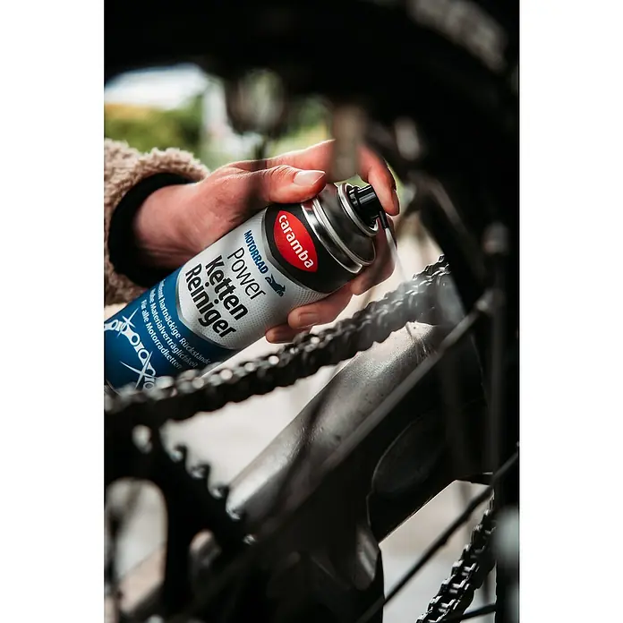 Caramba Kettenreiniger - 300 ml - Sprühdose Caramba Motorrad Power Kettenreiniger in Aktion, reinigt eine Motorradkette, um hartnäckige Rückstände zu entfernen und die Kette zu pflegen.