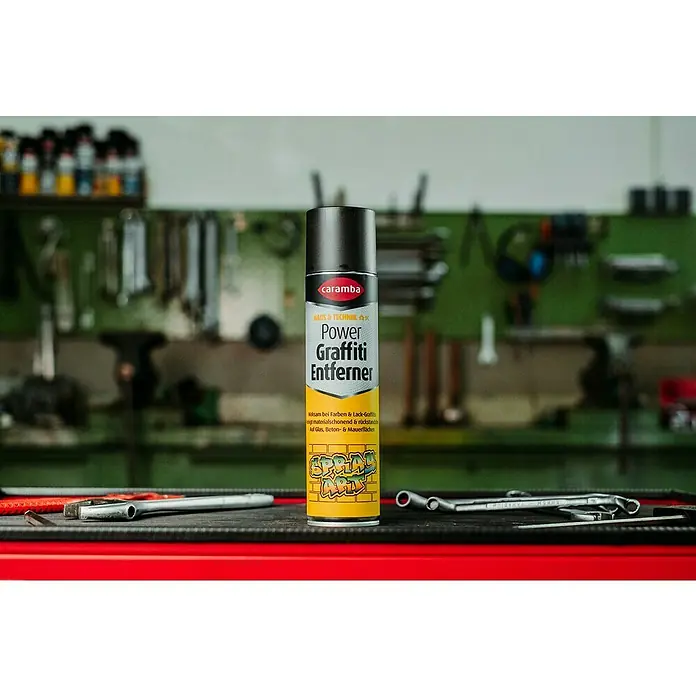 Caramba Graffiti-Entferner - 400 ml - Ein Sprühdose Caramba Power Graffiti Entferner vor Werkzeugen in einer Werkstatt.