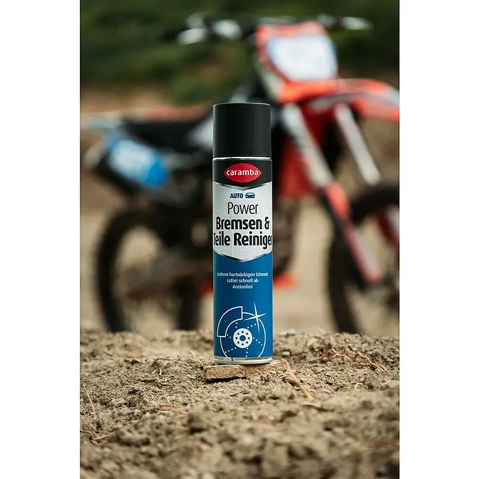 Caramba Bremsen- & Teilereiniger - 400 ml - Das Bild zeigt eine Dose Caramba Power Bremsen- & Teile Reiniger vor einem unscharfen Motorrad. Ideal für die Pflege Ihres Fahrzeugs.
