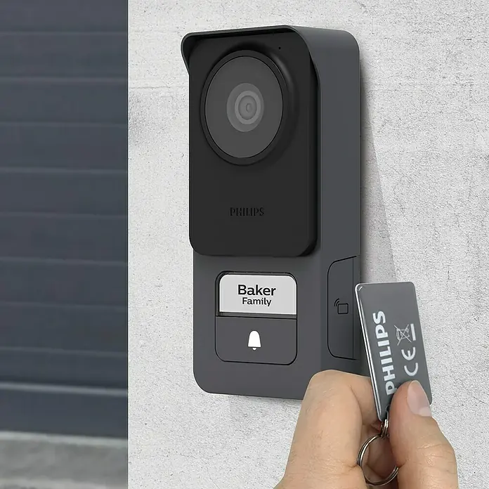 Philips WelcomeEye Farb-Video-Türsprechanlage Lite 2 - 1-Familienhaus - Nahaufnahme einer Philips-Türklingel mit Hand, die einen Schlüsselanhänger hält.