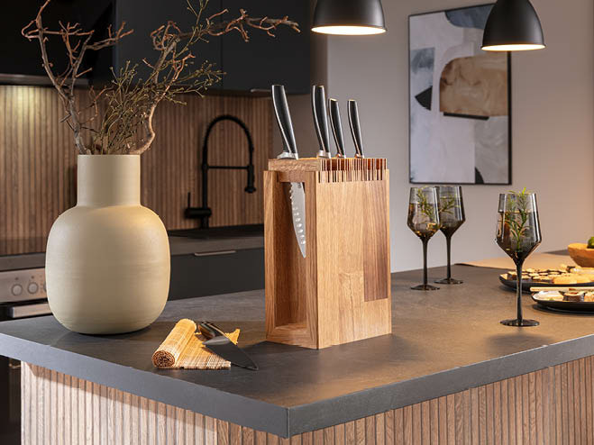 Messer mit Messerblock aus Holz, Vase und Weingläser auf der Kücheninsel