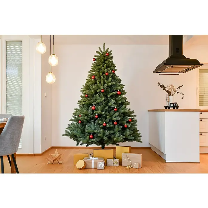 50 NRTH Künstlicher Weihnachtsbaum Vermont - Höhe: 210 cm, Grün, Standfuß - Festlicher Weihnachtsbaum mit roten Kugeln und Geschenken in einem hellen Wohnzimmer.